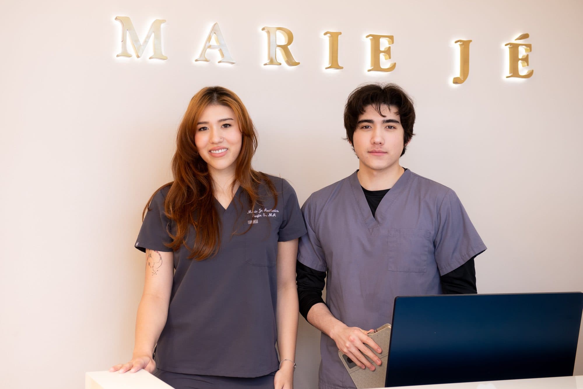 Two team members welcoming clients at the Marie Jé Aesthetics front desk